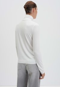 Weißer Rollkragenpullover mit langen Ärmeln, aus einem glatten Stoff gefertigt. Der Schnitt ist slim, mit einem einfachen, klaren Design und ohne sichtbare Muster.