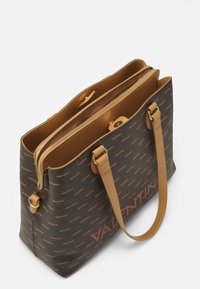 Bolso tote marrón de Valentino con asas en tono claro, compartimento central con cremallera y un patrón repetido del logo de Valentino sobre un fondo oscuro.