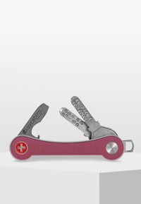 Outil multi-fonction de style suisse avec une poignée en aluminium rose, des outils en acier inoxydable argenté, y compris une lame et un porte-clés, au design compact.