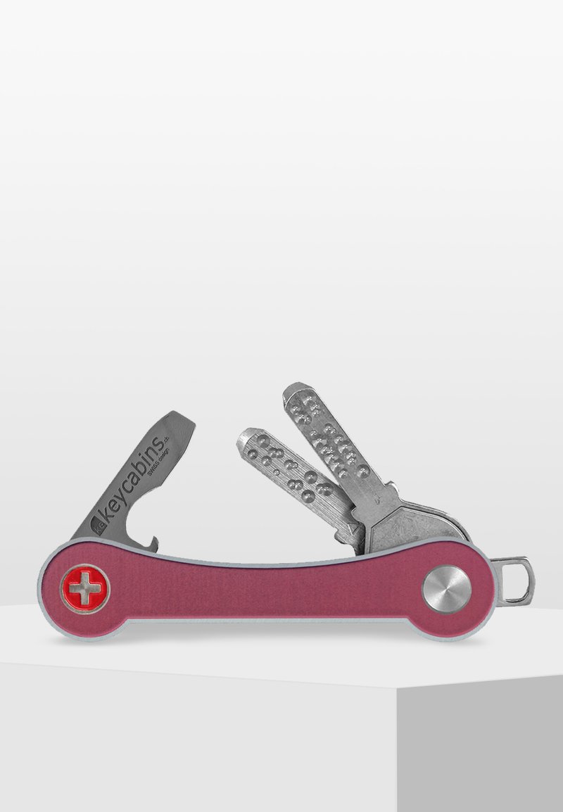 Outil multi-fonction de style suisse avec une poignée en aluminium rose, des outils en acier inoxydable argenté, y compris une lame et un porte-clés, au design compact.
