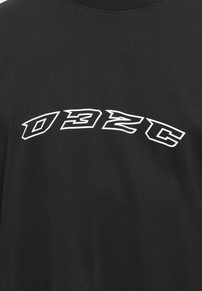 Black cotton t-shirt features a large, bold, white curved text "D32C" on the front, with a soft texture and crew neck design.