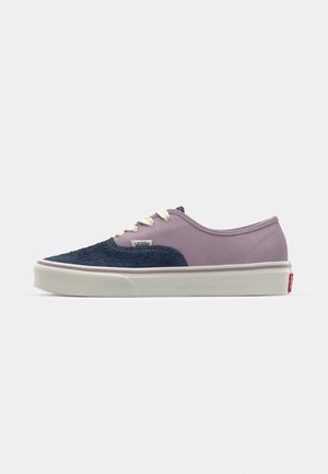 Lila och marinblå kanvas sneaker med texturerade detaljer, vita snören och en gummisula. Har varumärkeslogotyp på sidan och hälfliken.