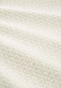 Tessuto bianco con un motivo geometrico testurizzato in tonalità più chiare, che crea un aspetto superficiale sottile ma dettagliato.