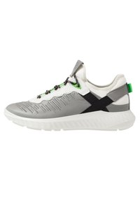 Chaussure de sport grise et blanche avec un dessus texturé, des accents noirs, des œillets verts et une semelle blanche. Présente un design à lacets avec des perforations.