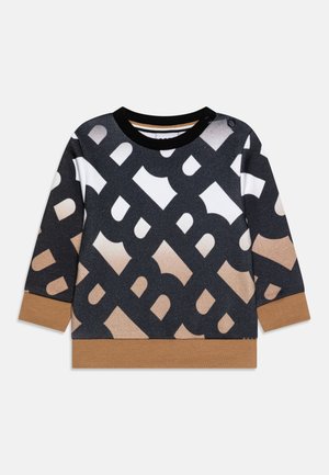 Genser i svart, hvitt og beige med et helsort logo-mønster. Har rund hals, lange ermer og brune mansjetter og nederkant.