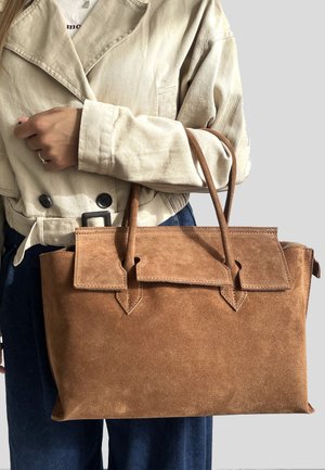 Borsa a tracolla in suede marrone con un design strutturato, dotata di chiusura a patta, due manici superiori e dettagli angolari. Superficie liscia in tutta la borsa.