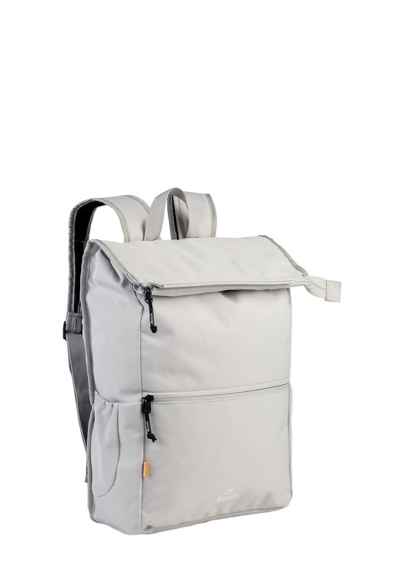 Lichtgrijze rugzak met een omvouwbare bovenkant, verstelbare schouderbanden, een voorvak met rits en een textuurstofafwerking. Accentkleuren zijn zwarte ritsen.
