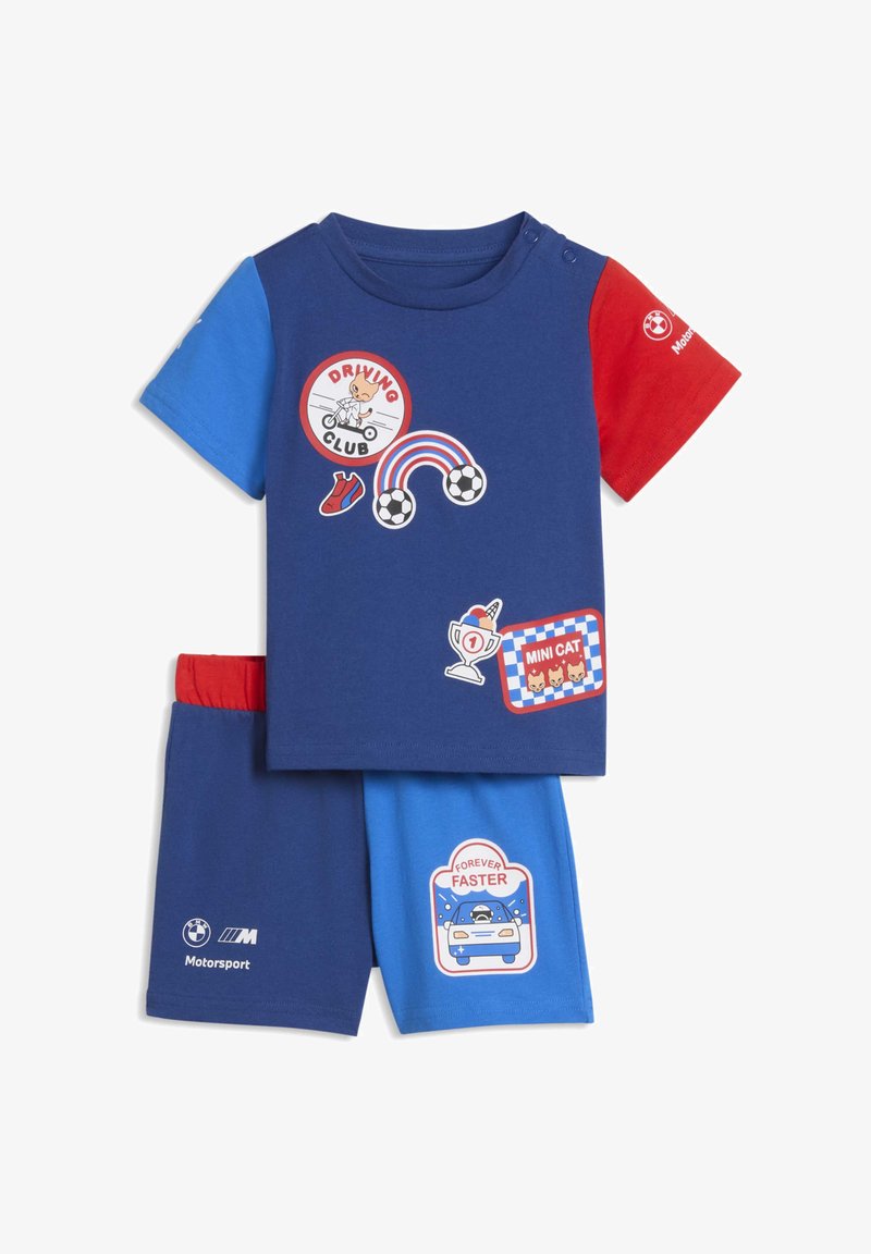 T-shirt en coton bleu à manches courtes avec accents rouges, présentant des imprimés graphiques et des motifs ; assorti à un short bleu. Texture douce, design sportif.