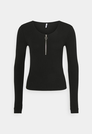 Top negro de manga larga con textura acanalada, cuello redondo y cremallera frontal plateada con tirador circular.