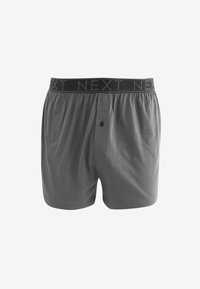 Graue Baumwollboxershorts mit einem schwarzen elastischen Bund, auf dem der Text "NEXT" wiederholt gedruckt ist. Sie verfügen über einen Knopf vorne und einen lockeren Schnitt.