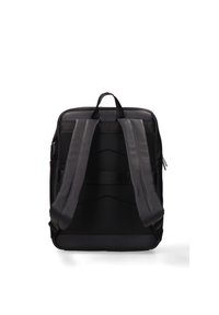 Zaino nero con superficie texturizzata, spallacci imbottiti e manico superiore. Il design include diverse cinghie orizzontali per la stabilizzazione.