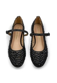 Des ballerines noires avec une tige texturée arborant un motif de perles noires. Elles ont une bride autour de la cheville et une semelle intérieure lisse beige.