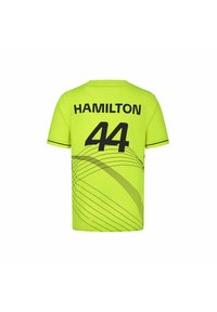 Żółto-zielona koszulka z czarnym napisem "HAMILTON" oraz numerem "44" z tyłu, z krzywymi czarnymi wzorami na tkaninie.