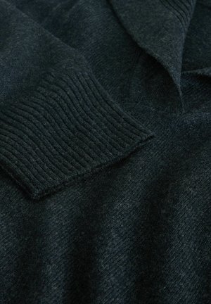 Dark wool sweater with ribbed cuffs, v-neck design, and a textured surface. The material appears soft and warm, suitable for colder weather.