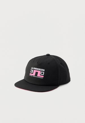 Gorra de béisbol negra con visera plana, con el logo "J.LINDEBERG 30 Year Anniversary" en blanco y rosa en el panel frontal.