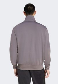 Ljust grå bomberjacka med ståendliga krage, ribbade ärmslut och nederkant, slät textur och en minimalistisk design.