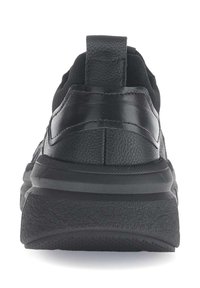 Zwarte sneaker met een textuurlederen bovenwerk, stevige hielkap en een dikke rubberen zool. Achteraanzicht benadrukt het minimalistische ontwerp en de stikdetails.