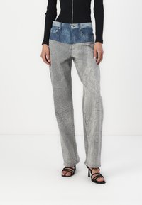 Pleekinud hall denimist teksad tekstureeritud viimistlusega, millel on kontrastne tumehall vöökoht ja esikotid, kohandatud lõige ning sirged sääred.