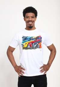 Hvid bomulds t-shirt med et farverigt grafisk design af fire vintage biler i blå, gul, rød og orange. Kortærmet og med rund hals.
