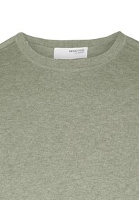 Grønn genser med rund hals, laget av mykt strikket stoff. Har en ribbestrikket tekstur og et lite merke på baksiden.