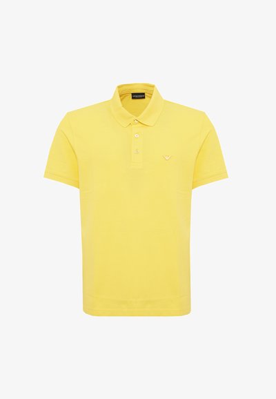 Polo shirt gialla in cotone, con colletto classico, maniche corte, patta con tre bottoni e un piccolo logo sul petto.