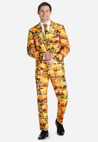 Traje de colores brillantes con un estampado de comida, predominantemente hamburguesas y patatas fritas, con una textura brillante. Incluye una camisa blanca y una corbata.