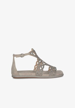 Grijze suède sandaal met decoratieve uitsnijdingen en glinsterende accenten. Platte zool, enkelbandje met metalen gesp.