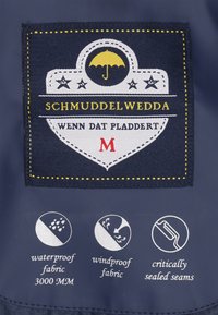 Aufnäher mit gelbem Regenschirm und Sternen, Text "Schmuddelwedda wenn dat pladdert M," mit Symbolen für wasserdichtes, winddichtes Gewebe und versiegelte Nähte.