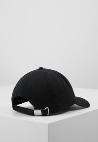 Chapéu de beisebol preto em algodão com uma textura suave, aba curva e uma alça ajustável com uma fivela metálica na parte de trás.