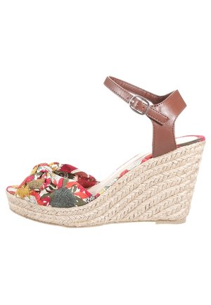 Kile-sandal med flettet jutesål, med en øvre del i blomsterstof i rød og grøn, samt en brun læderrem omkring anklen med spænde.