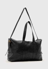Black leather bag with a textured finish, dual handles, and an adjustable strap. Features a gold zipper and side pocket.