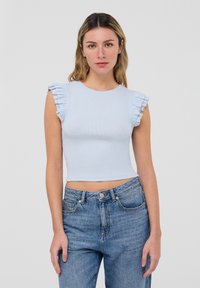 Top corto a righe blu chiaro con maniche corte a volant, abbinato a jeans in denim blu a vita alta. Scollo rotondo semplice, design minimale.