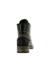 Stivale alla caviglia in pelle nera con pannello posteriore in camoscio, accento marrone testurizzato e colletto imbottito. Presenta un tacco basso a blocco e chiusura con zip.