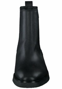 Bota de tobillo de cuero negro con textura suave, puntera ligeramente redondeada, costura lateral y una etiqueta de tira en la parte posterior para facilitar su puesta.