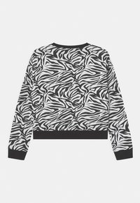 Felpa corta in bianco e nero con design a stampa zebra, maniche lunghe e fascia elastica a coste nera in vita e ai polsi.