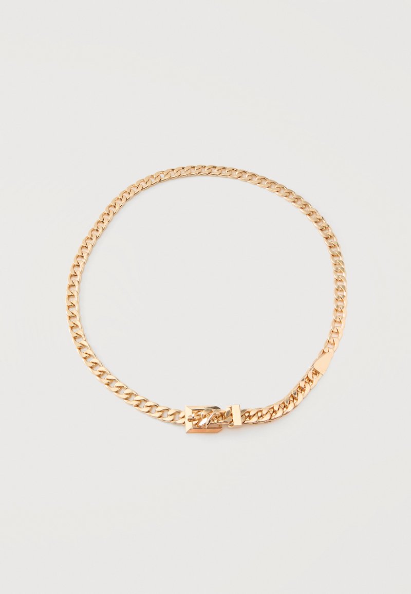 Collar con cadena en tono dorado con un cierre rectangular pulido sobre un fondo claro y liso.
