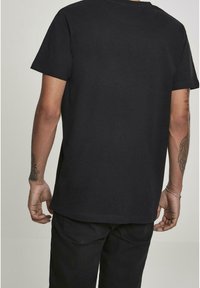 Zwarte katoenen T-shirt met korte mouwen, een ronde halslijn en rechte snit, zonder zichtbare logo's of patronen op de rug.