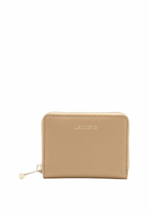 Portefeuille rectangulaire en cuir beige avec fermeture éclair dorée et logo Lacoste embossé au centre avant.
