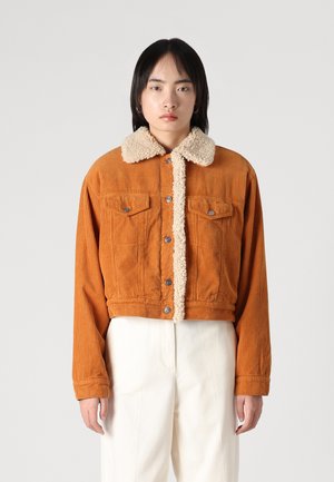Orange corduroy cropped jacket with a beige faux fur collar and button closure, featuring two chest pockets and ribbed cuffs.
