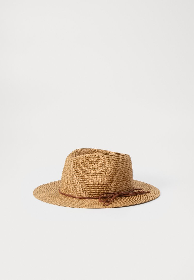 Sombrero de paja tejido en marrón claro con una textura suave. Presenta una cinta estrecha marrón alrededor de la corona y un ala ancha y plana.