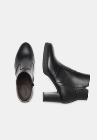 Black leather ankle boots with a tapered toe, side zip closure, and a chunky heel. Features smooth texture and stitching detail.