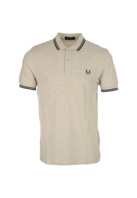 Polo beige en coton avec des poignets et un col à rayures noires. Il présente un petit logo brodé sur la poitrine. Manches courtes, coupe ajustée.