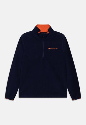 Pull-over à fermeture éclair quart en bleu marine avec col intérieur orange et logo Champion orange sur la poitrine et les poignets des manches.