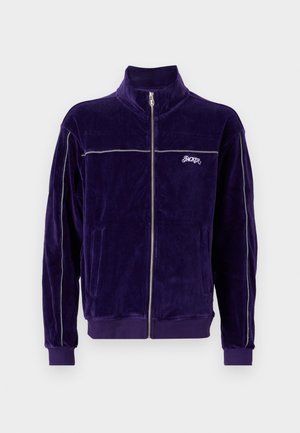 Purple velour zip-up jacket with high collar, silver accent stripes, and embroidered logo. Features two front pockets and ribbed cuffs.