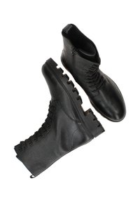 Zwarte leren enkelboots met een gestructureerd oppervlak, voorzien van een stevige rubberen zool, vetersluiting aan de voorkant en een zijrits voor gemakkelijk aan- en uittrekken.