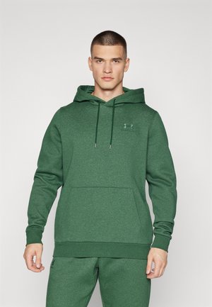 Felpa con cappuccio verde realizzata in tessuto texturizzato, dotata di tasca frontale e un piccolo logo sul petto. Il design include un cappuccio regolabile con cordoncino.