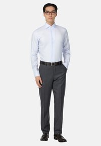 Světle modrá kostkovaná košile s dlouhými rukávy, kombinovaná se tmavě šedými společenskými kalhotami a černým opaskem, doplněná černými koženými botami.