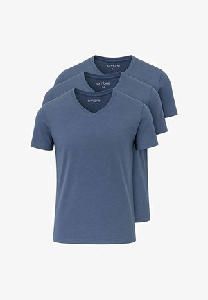 Blaues V-Ausschnitt-T-Shirt aus weichem Stoff, kombiniert mit hellgrauen Jogginghosen mit elastischen Bündchen und weißen Sneakers, die ein lässiges Outfit kreieren.