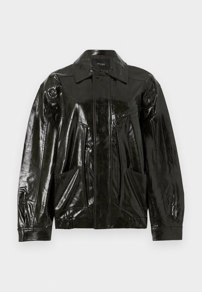 Chaqueta de cuero negra y brillante con cuello, cremallera frontal y dos grandes bolsillos con parche. Tiene un corte holgado con puños elásticos.