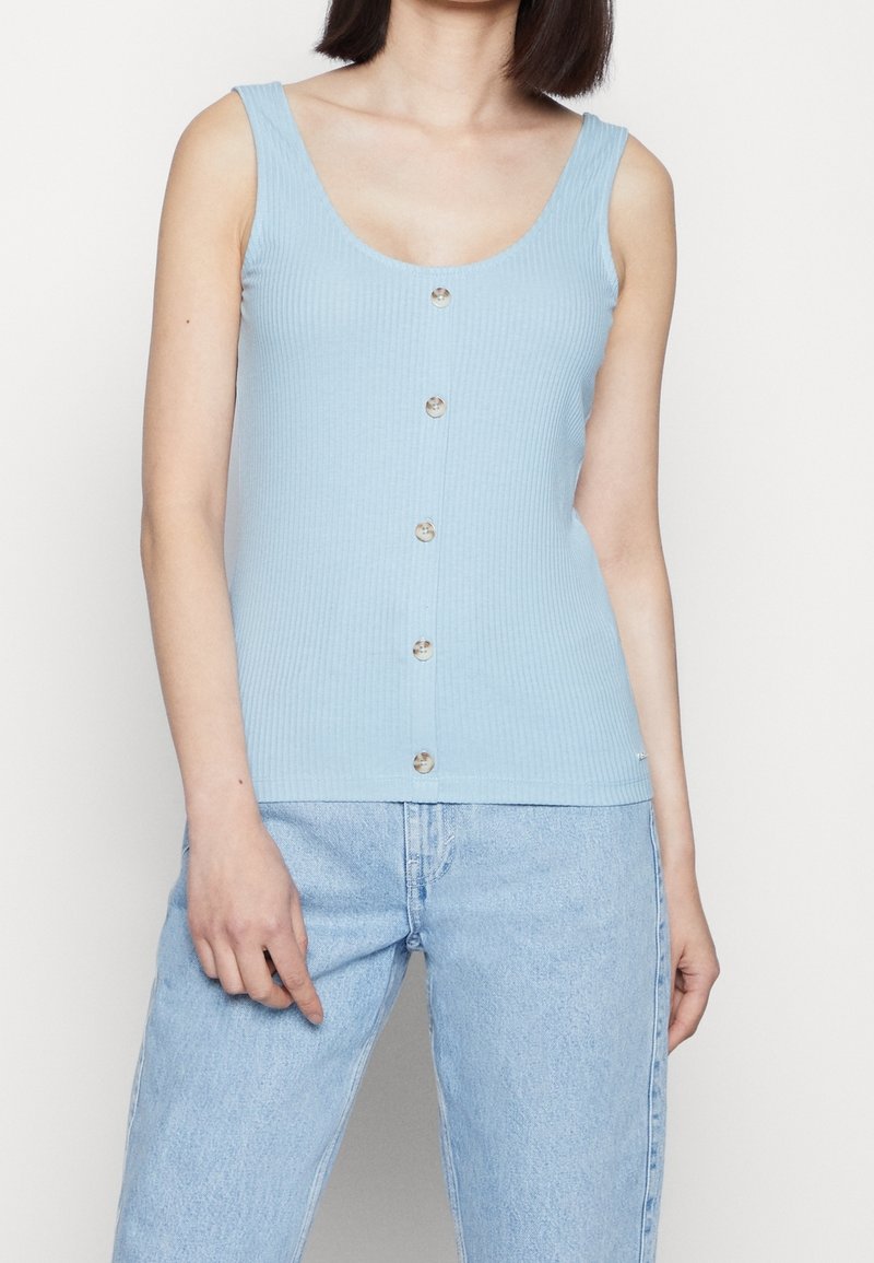 Light blue ribbed tank top with a scooped neckline, six-button front closure, and wide shoulder straps. Smooth texture, casual design.